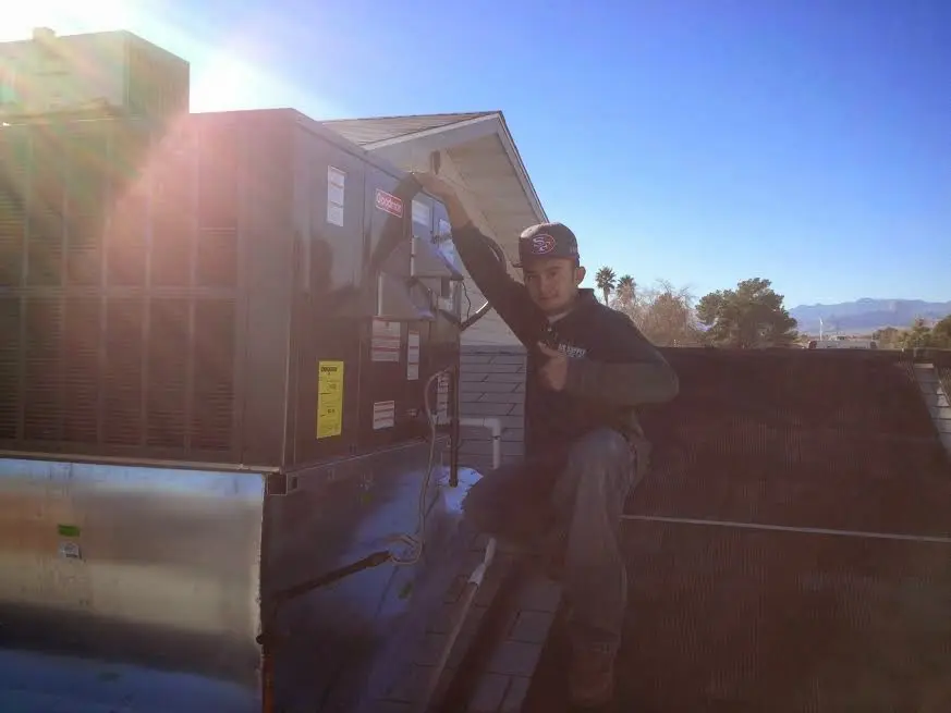 HVAC technician performing AC Tune-Up on a rooftop unit in Windsor